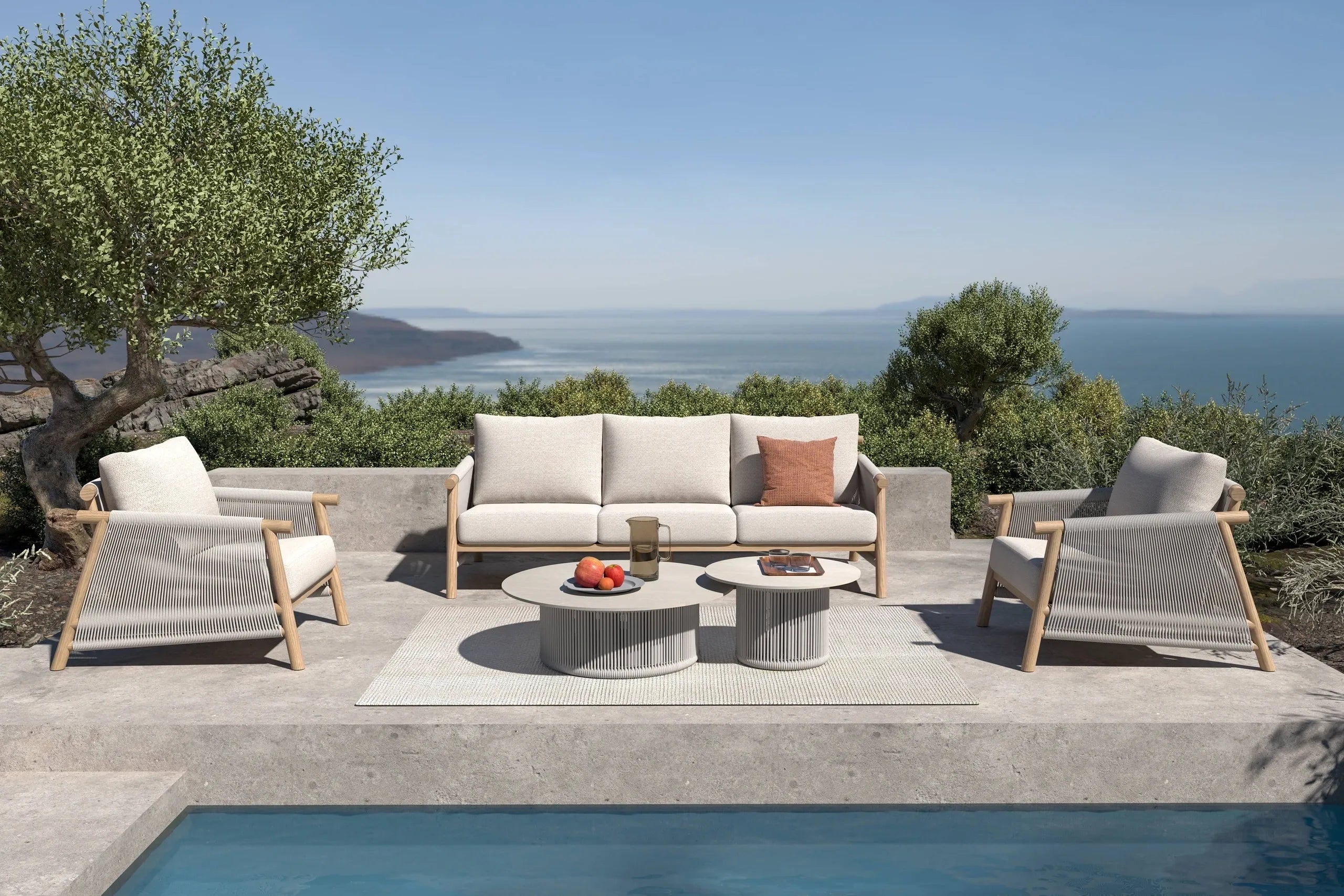 Outdoor lounge setting on a stone terrace overlooking the sea