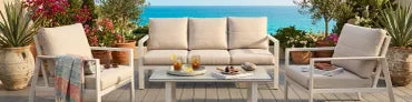 Cozy outdoor seating with ocean view and floral accents.